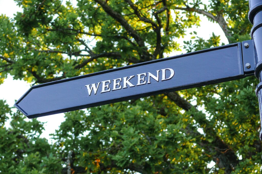 Ein Bild von einem Straßenschild, bzw. Wegweiser auf dem "Weekend" steht.