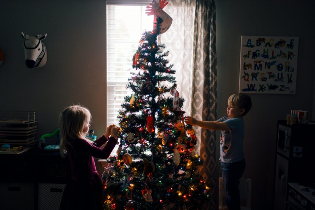Weihnachten ist für Kinder immer etwas Besonderes. Hier schmücken zwei Kinder einen Weihnachtsbaum.