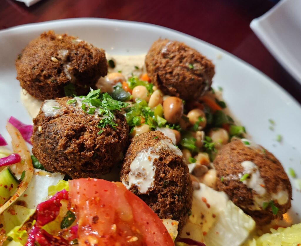 Falafel angerichtet mit Tahini und Gemüse.