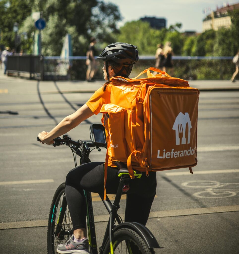 Bester Lieferservice Münster? Frau mit Lieferando Rucksack auf Fahrrad