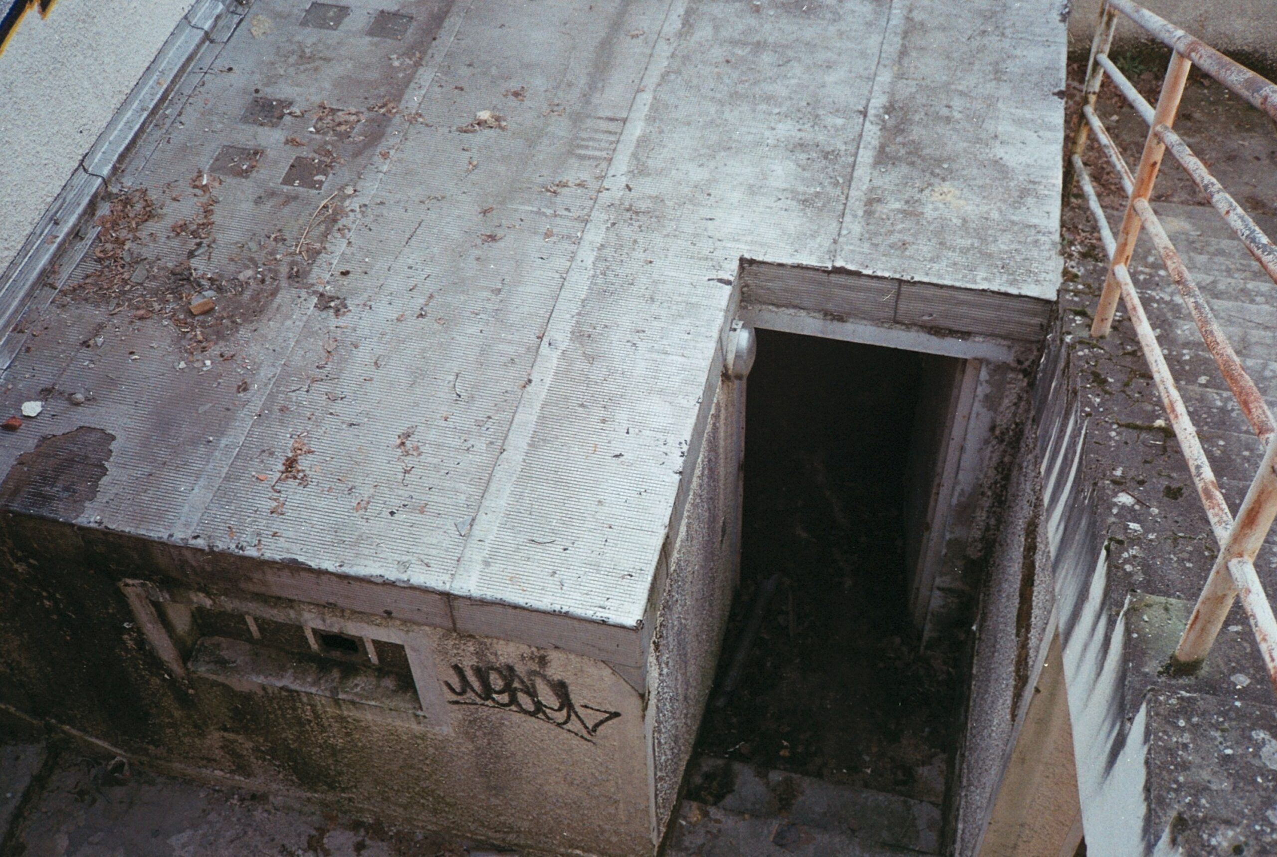Bunker in Münster aus dem Zweiten Weltkrieg sind bis heute sichtbare Zeugnisse des Luftkriegs. Während des Zweiten Weltkriegs wurden in Münster zahlreiche Luftschutz-Bunker – sowohl oberirdische Hochbunker als auch unterirdische Anlagen – errichtet, um der Zivilbevölkerung Schutz vor Bombenangriffen zu bieten. Diese massiv aus Beton gebauten Schutzräume prägten einst das Stadtbild und einige von ihnen existieren noch heute. Der folgende Artikel gibt einen Überblick über die verschiedenen Bunker in Münster, ihre historische Nutzung im Zweiten Weltkrieg und ihren heutigen Zustand. Dabei werden oberirdische Bunker ebenso betrachtet wie unterirdische Anlagen und es wird beleuchtet, wie diese Relikte heute genutzt oder als Denkmäler erhalten werden. Historischer Hintergrund: Luftschutz in Münster im Zweiten Weltkrieg Münster war im Zweiten Weltkrieg als Gauhauptstadt von Westfalen-Nord und Sitz des Luftgaukommandos ein strategisch wichtiger Standort. Entsprechend wurde die Stadt häufig Ziel alliierter Luftangriffe. Zwischen 1940 und 1945 heulten in Münster über 1.100 Fliegeralarme, und die Bevölkerung suchte Schutz in den Bunkern. Insgesamt wurden in der Stadt rund zehn große Luftschutzbunker gebaut. Die meisten dieser Betonkolosse entstanden ab 1941/42, als der Luftkrieg an Intensität zunahm. Ihre Wände waren bis zu zwei Meter dick und die Decken etwa 1,4 Meter stark, um den Bombentreffern standzuhalten. Viele Münsteraner Bunker wurden von dem Architekten Edmund Scharf entworfen und verfügten über besondere Tarnmaßnahmen. Um aus der Luft weniger als militärische Ziele erkennbar zu sein, passte man das Erscheinungsbild der Bunker an zivile Gebäude oder historische Bauwerke an. So integrierten sich einige Bauten erstaunlich gut ins Stadtbild und sollten auf den ersten Blick nicht wie Bunker wirken. Dieser Aspekt der Tarnung zeigt sich an mehreren Beispielen in Münster. Oberirdische Bunker in Münster und ihre Tarnung Oberirdische Hochbunker (auch „Hochbauten“ genannt) prägten das damalige Stadtbild. Jeder dieser Bunker sah anders aus, da sie jeweils als zivile Gebäude getarnt geplant waren. Ein markantes Beispiel ist der Hochbunker an der Lazarettstraße: Dieser 1940/41 errichtete Bunker wurde äußerlich wie eine mittelalterliche Festung gestaltet, mit Zier-Rundtürmen, einer Zugangsbrücke und einem umliegenden Graben als Anspielung auf eine Burganlage. Wer den massivem Ziegelbau mit den bewachsenen Türmen sieht, könnte ihn für ein altes Fort halten – genau dieser Eindruck war beabsichtigt. Tatsächlich verbarg der Lazarettbunker hinter seinen Fassaden einen Schutzraum für bis zu 530 Menschen. Im Inneren ist die originale Ausstattung aus Kriegszeiten weitgehend erhalten, was ihn heute zu einem authentischen Zeitzeugnis macht. Ein weiteres Beispiel für kreative Tarnung war der Hochbunker an der Von-Kluck-Straße. Dieser fünfstöckige Bunker – der höchste in Münster – wurde 1942/43 auf dem Schulhof der Marienschule gebaut. Seine Fassade war als griechischer Tempel konzipiert, komplett mit Pfeiler-Andeutungen, um das militärische Aussehen zu verschleiern. Trotz dieser Tarnung erhielt der Von-Kluck-Bunker am 18. November 1944 einen Bombentreffer, überstand ihn jedoch ohne gravierende Schäden. Auf dem Dach dieses Hochbunkers befand sich sogar eine Flak-Stellung zur Luftverteidigung. Mit Platz für rund 2.000 Menschen zählte der Bunker zu den größten Schutzbauten der Stadt. Auch andere Hochbunker in Münster erhielten individuelle Gestaltungen: So sollte der Bunker am Hermannstadtweg ursprünglich ein Satteldach mit Wandmalereien im Heimatschutzstil bekommen. Zwar wurde die Tarn-Fassade dort nicht vollendet, doch auch dieser Betonbau hebt sich äußerlich von einem rein militärischen Aussehen ab. Insgesamt zeigt die Tarnung der Münsteraner Bunker, wie die NS-Bauplanung versuchte, die Luftschutzbauten in das städtische Umfeld einzupassen und gegnerische Bomber zu täuschen. Beispiele erhalten gebliebener Hochbunker und ihre heutige Nutzung Trotz Kriegsende und späterem Stadtumbau sind einige der großen Hochbunker Münsters bis heute erhalten. Drei ehemalige Bunker stehen sogar unter Denkmalschutz. Zu diesen gehört der bereits erwähnte Lazarettstraßen-Bunker, der sich im Besitz der Stadt Münster befindet und wegen seiner historischen Bedeutung als Baudenkmal gilt. Ein weiterer denkmalgeschützter Bunker ist der sogenannte Schützenhofbunker an der Wörthstraße im Südviertel. Dieser langgestreckte Bunker (ca. 61 m lang, 14,5 m breit, knapp 10 m hoch) wurde 1941/42 erbaut. Bei einem Bombentreffer im November 1944 wurde seine Decke beschädigt; die Druckwelle tötete 68 Menschen, die im Inneren Schutz gesucht hatten. Eine Gedenktafel an der Außenwand erinnert heute an diese Opfer. Nach dem Krieg erhielt der Schützenhofbunker eine neue Nutzung: In den vergangenen Jahren wurde der massive Bau privat umgebaut und enthält jetzt rund 38 Mietwohnungen auf etwa 1.600 Quadratmetern Fläche. Von außen ist die wuchtige Betonstruktur noch deutlich erkennbar, doch moderne Fenster und ein aufgesetztes Dachgeschoss zeigen die Wohnnutzung an. Dieser Umbau demonstriert eindrucksvoll, wie ein ehemaliger Luftschutzbunker in Münster erfolgreich in Wohnraum umgewandelt wurde – ohne seine geschichtliche Substanz ganz zu verlieren. Die Öffentlichkeit hat allerdings normalerweise keinen Zutritt, da es sich um Privatbesitz handelt. Ebenfalls noch vorhanden ist der Hochbunker am Hermannstadtweg (Geistviertel). Dieses 1941/42 errichtete Bauwerk mit ca. 2 Meter dicken Wänden umfasste einst 106 Räume. Anders als viele andere Bunker wurde er nicht abgerissen, sondern bereits seit Anfang der 1950er zivil genutzt. Heute befindet sich der Bunker Hermannstadtweg im Eigentum der Bundesanstalt für Immobilienaufgaben (BImA) und beherbergt diverse Künstlerateliers, Proberäume und Werkstätten. Unter anderem hat der Künstler Andreas Rosenthal dort seit rund 40 Jahren sein Atelier eingerichtet. Äußerlich ist der unverputzte Betonbau noch als solcher erkennbar, da das geplante Satteldach nie komplett fertiggestellt wurde. Trotzdem fügt sich der ehemalige Bunker inzwischen unauffällig ins Viertel ein, da er von Gewerbe und Kreativnutzung belebt wird. Ein ungewöhnliches Nachkriegs-Schicksal hatte ein Hochbunker im Stadtteil St. Mauritz. Dieser Bunker wurde nach 1945 in ein Schulgebäude umgewandelt und lange Zeit umgangssprachlich als „Bunkerschule“ bezeichnet. Ab 1949 diente er zunächst provisorisch als Volksschule, woraus später die Margaretenschule hervorging. Das massive Gebäude wurde teils entfestigt (entmilitarisiert) und mit Fenstern versehen, sodass es schließlich das Aussehen einer „etwas wehrhaften Unterrichtsstätte“ bekam. Bis heute wird es als Schulhaus genutzt und steht – ebenso wie der Lazarett- und der Schützenhofbunker – unter Denkmalschutz. Dieses Beispiel zeigt, wie flexibel die Stadt Münster nach dem Krieg mit den Bauten umging: Aus einem Ort des Schutzes vor Bomben wurde ein Ort des Lernens für Kinder. Nicht alle Bunker haben indes überdauert. Einige der ehemals zehn Anlagen wurden im Laufe der Jahrzehnte abgerissen oder stehen leer. Ein Hochbunker an der Emsstraße (Ecke Elbestraße, im Mauritzviertel), bekannt als „Emsbunker“, blieb viele Jahre ungenutzt und diente zeitweise als Lagerraum. Kürzlich wurde er von einem Investor gekauft, komplett zurückgebaut und abgerissen, um Platz für Neubauwohnungen zu schaffen. An seiner Stelle entstehen bis 2027 moderne Wohngebäude. Dieses Schicksal zeigt, dass die Zukunft mancher Bunker auch der städtebaulichen Entwicklung weichen muss, wenn keine schützende Denkmaleinstufung vorliegt. Unterirdische Bunker und Luftschutzkeller Neben den auffälligen Hochbunkern gab es in Münster auch unterirdische Luftschutzanlagen. Die bedeutendste darunter befindet sich unter dem Hauptbahnhof Münster. In den Jahren 1941/42 ließ die Deutsche Reichsbahn direkt unter dem Bahnhof einen großen Tiefbunker bauen, der rund 2.000 Menschen Schutz bieten sollte. Diese Anlage bestand aus ausgedehnten unterirdischen Räumen und starken Stahlbetonwänden. Trotz heftiger Bombardements auf die Bahnanlagen – allein 102 Luftangriffe der Alliierten galten dem Münsteraner Bahnhof und Güterbahnhof – überstand der Bahnhofsbunker den Krieg. Er wurde im Frühjahr 1945 von alliierten Truppen erobert, ohne dass es dabei zu Personenschäden kam. Bemerkenswerterweise ist dieser Bunker unter dem Hauptbahnhof auch heute noch erhalten. Während des Kalten Krieges wurde er sogar weiter ausgebaut und modernisiert, um im Falle eines Atomkriegs als Hilfskrankenhaus und Zivilschutzraum zu dienen. Hinter meterdicken Stahltüren verbergen sich dort Schleusen und Schutzräume, die jedoch der Öffentlichkeit normalerweise nicht zugänglich sind. Der Tiefbunker schlummert im Verborgenen unter dem Bahnhofsvorplatz – ein kaum sichtbares Relikt des Zweiten Weltkriegs mitten in der Stadt. Neben diesem großen Bahnhofsbunker gab es in Münster weitere unterirdische Schutzorte. Viele Wohnhäuser waren mit Luftschutzkellern ausgestattet, in die sich Bewohner bei Alarm zurückzogen. Bis heute finden sich an einigen älteren Häuserfassaden noch eingemeißelte oder gemalte Luftschutzkeller-Pfeile, die den Weg zu diesen Kellern wiesen. Solche Pfeile – kleine Dreiecke oder Pfeilsymbole mit der Aufschrift "LS-Raum" oder ähnliches – sind verbliebene Spuren der Luftschutzmaßnahmen im Stadtbild. Auch die Tunnelanlagen der städtischen Befestigungen (etwa am Zwinger oder in ehemaligen Kasernen) wurden zeitweise als Bombenschutzräume genutzt, soweit es möglich war. Ein Beispiel für kleinere spezielle Bauten der Reichsbahn sind sogenannte Rundbunker: Am Rande des Güterbahnhofs in Münster standen mehrere runde Betonbunker, die dem Schutz von Bahnpersonal dienten. Einige Überreste solcher Rundbunker sind ebenfalls erhalten geblieben, gut getarnt im Bewuchs oder integriert in heutige Nutzungen. Vom Kriegsrelikt zum Denkmal: Heutiger Umgang und Gedenken Ein großer Teil der Bunker in Münster ist heute entweder einer neuen Nutzung zugeführt oder als Mahnmal erhalten. Drei ehemalige Luftschutzbunker – der Lazarettbunker, der Schützenhofbunker und die Bunkerschule St. Mauritz – stehen auf der städtischen Denkmalliste und werden als historische Bauwerke anerkannt. Dies bedeutet, dass ihr Erhalt im öffentlichen Interesse liegt. Die Stadt Münster bemüht sich, diese Relikte des Zweiten Weltkriegs in das kollektive Gedächtnis zu rücken. So wurden etwa im Rahmen des bundesweiten Tags des offenen Denkmals am 10. September 2023 erstmals seit langer Zeit Bunker der Öffentlichkeit zugänglich gemacht. An diesem Tag konnten interessierte Bürger den Hochbunker an der Lazarettstraße und den Schützenhofbunker von innen besichtigen – ein Angebot, das regen Zuspruch fand. Solche Veranstaltungen sollen bewusst machen, welche bedrückende Zeitgeschichte in den massiven Mauern steckt. Auch durch Gedenktafeln wird an die Geschichte der Bunker erinnert. Der Schützenhofbunker trägt, wie erwähnt, eine Tafel für die 68 Opfer des Bombentreffers von 1944. Am Lazarettbunker wiederum informieren Hinweisschilder über die außergewöhnliche Architektur und die Tarnung als Burg. Initiativen von Heimatvereinen und Geschichtsinteressierten bieten außerdem gelegentlich Führungen zu den Bunkerstandorten an, um die Erinnerung wachzuhalten. In Publikationen und Online-Archiven werden Fotos und Zeitzeugenberichte zu den Münsteraner Bunkern gesammelt, damit dieses Kapitel der Stadtgeschichte nicht in Vergessenheit gerät. Schließlich stellt sich die Frage nach der Zukunft dieser Bauten. Einige, wie der Emsbunker, weichen der Stadtentwicklung und verschwinden zugunsten neuer Gebäude. Andere wie der Bunker Hermannstadtweg haben sich längst in den Alltag integriert und erfüllen eine neue Funktion. Wieder andere stehen zwar leer, sind aber als Mahnmale erhalten. So sind die Bunker in Münster heute vielgestaltig: Sie dienen als Wohnungen, Lager, Ateliers oder Schulgebäude, oder sie ruhen still und erinnern an die Schrecken des Krieges. Fazit: Die Bunker in Münster aus dem Zweiten Weltkrieg erzählen von Angst, Schutzsuche und Überlebenskampf während der Luftangriffe. Oberirdisch wie unterirdisch waren sie für Tausende Münsteraner lebensrettend. Heute sind sie stumme Zeugen der Geschichte – teils vergessen im Stadtbild, teils bewusst konserviert. Indem man diese Betonrelikte bewahrt und ihrem Schicksal gedenkt, hält Münster die Erinnerung an die dunklen Zeiten des Bombenkriegs lebendig und mahnt zugleich zum Frieden. Quellen: Stadtarchiv Münster, Zeitungsberichte und Denkmaldatenbanken über Münsteraner Bunker, sowie lokale Initiativen und historische Dokumentationen.