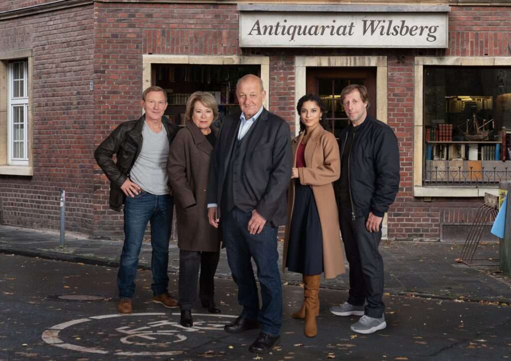 Antiquar und Privatdetektiv Georg Wilsberg (Leonard Lansink, M.) ist immer knapp bei Kasse und daher öfter als Privatdetektiv unterwegs. Dabei mischt er sich regelmäßig in die Ermittlungen von Hauptkommissarin Anna Springer (Rita Russek, 2.v.l.) und Kriminaloberkommissar Overbeck (Roland Jankowsky, l.) ein. Unterstützung erhält Wilsberg von der Anwältin Dr. Tessa Tilker (Patricia Meeden, 2.v.r.) und Ekki Talkötter (Oliver Korittke, r.).