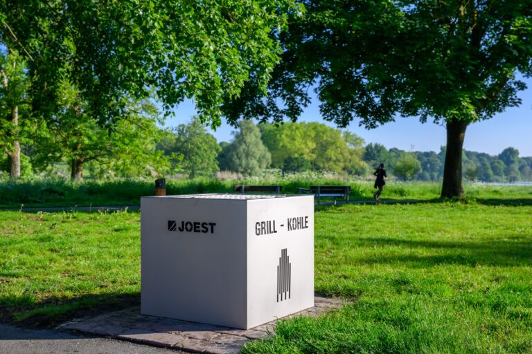 Am Aasee in Münster steht eine neue Grillaschetonne aus Edelstahl. Die Stadt testet das Modell und will beschädigte Behälter schrittweise ersetzen.