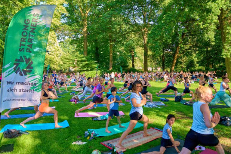 Sundowner-Yoga-Picknick Münster: Yoga, Picknick und Austausch im Schlossgarten bei sommerlichen Temperaturen.